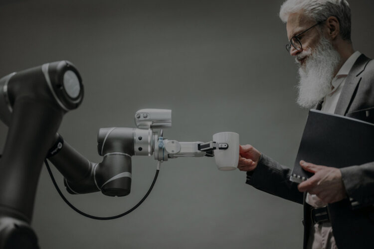 A robot arm handing a man a mug of coffee